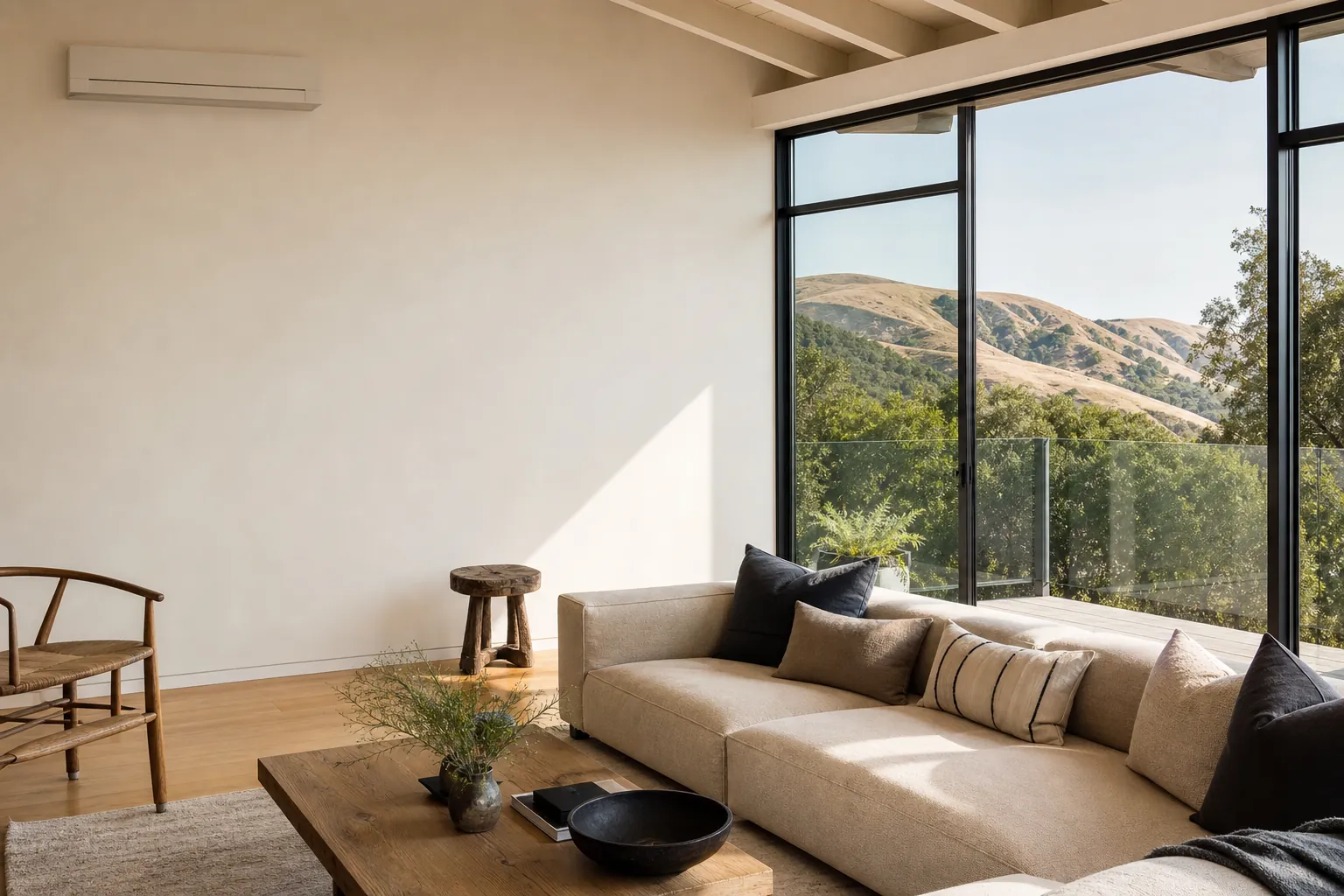 Sleek white ductless mini-split head mounted high on the wall of a bright, minimally furnished modern Marin living room.